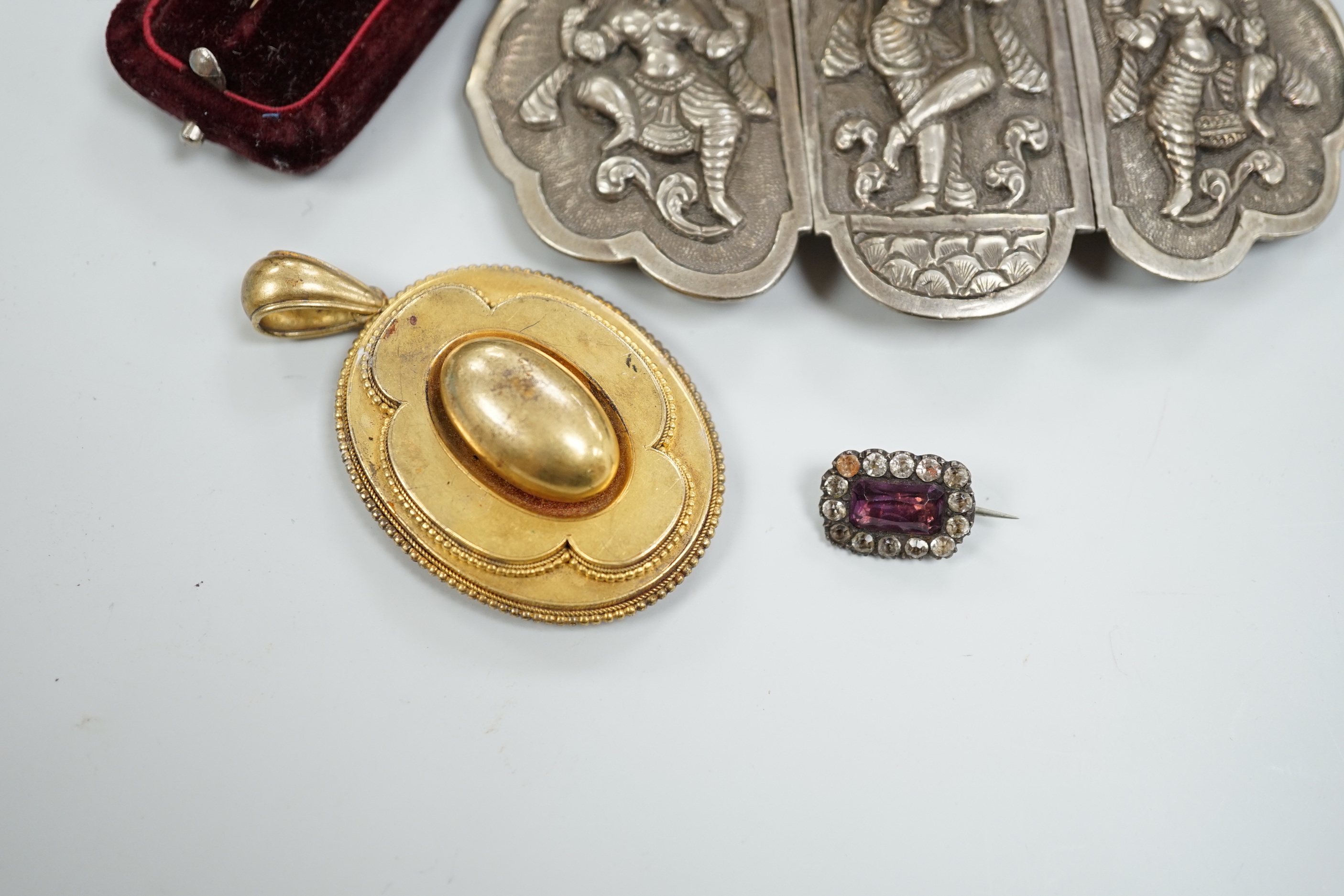 A Victorian yellow metal oval morning locket, with hair beneath a glazed panel verso, overall 56mm and four other items including a pinchbeck bangle.